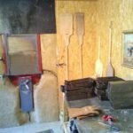 Un mur en terre/paille vient entourer la gueule du four. Il dispose de deux soles tournantes grâce au volant central.