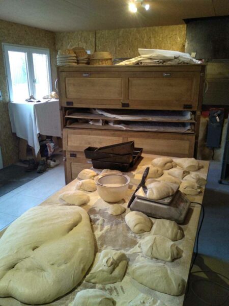 Division, pesée et façonnage du pain de Campagne. Les pâtons vont ensuite fermenter plusieurs heures dans le parisien (ancien meuble en bois)